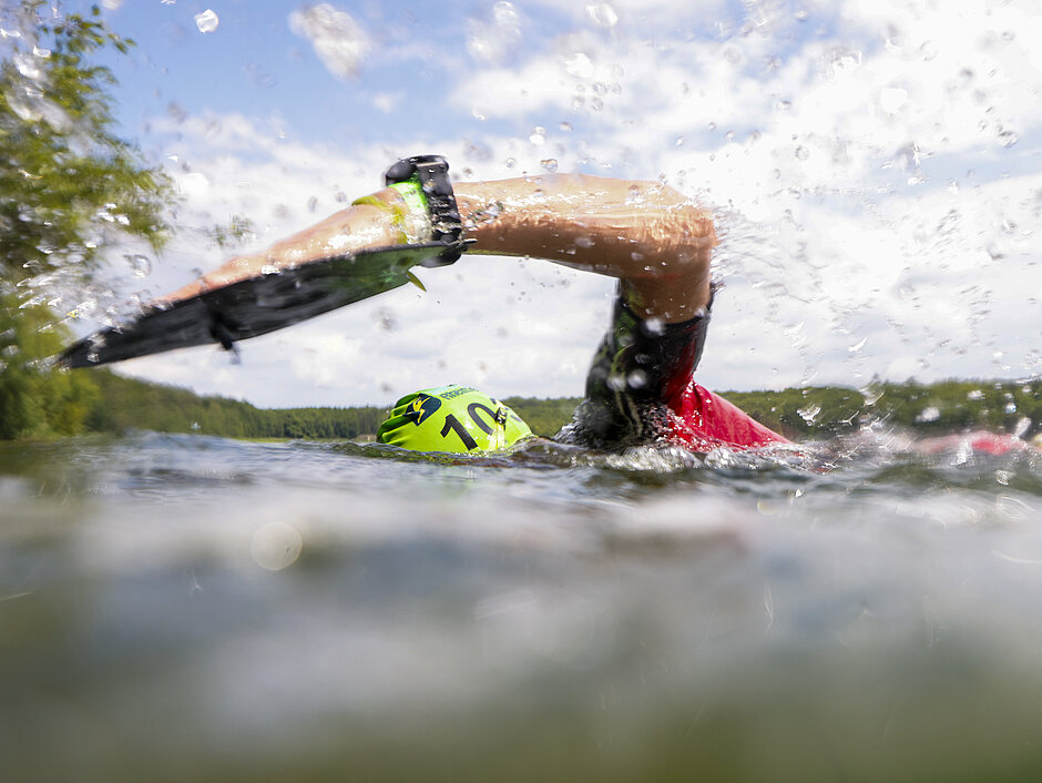SwimRun Challenge: Schwimmer:in im See, Kopf und Arm ragen aus dem Wasser © SCC EVENTS / Jean-Marc Wiesner 