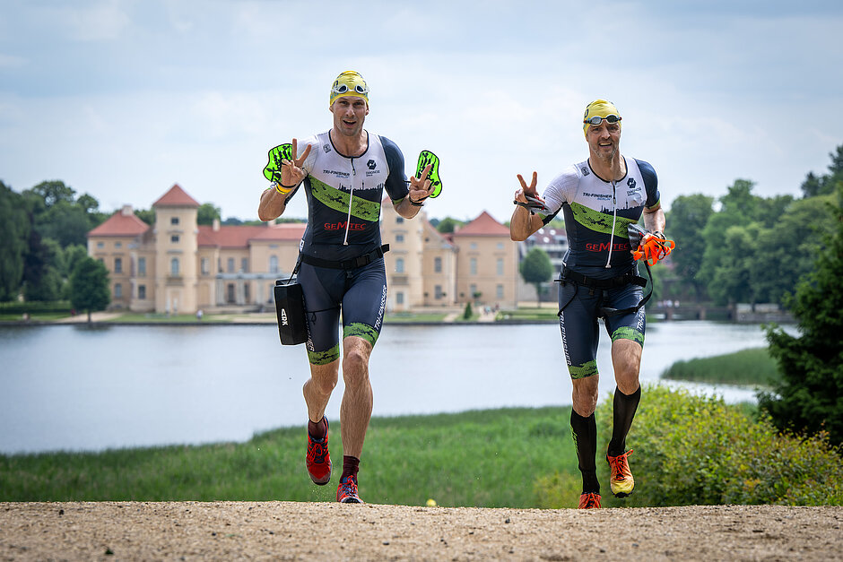 SwimmRun 2023: Team of 2 male participants running up a hill, the castle in the background © SCC EVENTS / Tilo Wiedensohler
