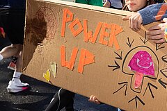 Homemade cardboard sign with the words “Power Up.”