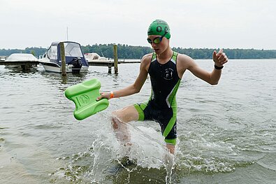SwimRun Rheinsberg 2021: Jugendlicher Teilnehmer erreicht das Ufer und steigt aus dem Wasser