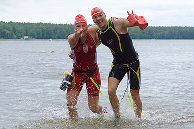 SwimRun 2019: Couple get out of the water and show victory signs to the camera © SCC EVENTS/Camera4