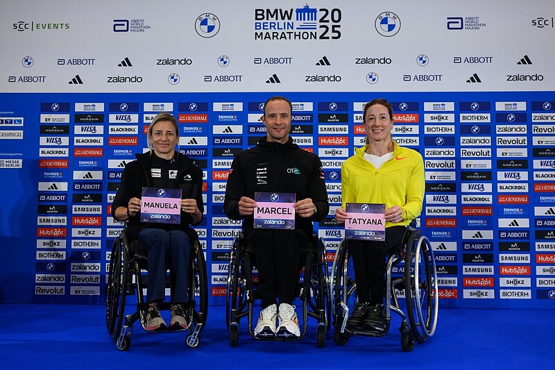 Von links nach rechts: Manuela Schär, Marcel Hug und Tatyana McFadden halten ihre Startnummern in die Kamera.