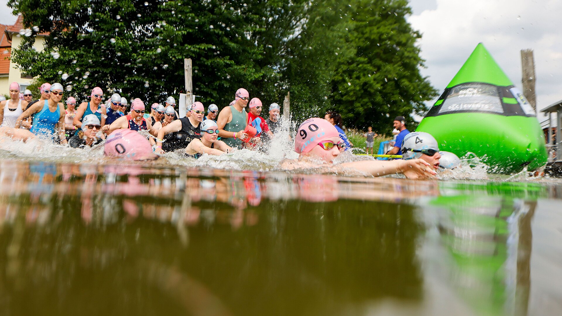 SwimRun: Participants enter the water and pass a green buoy © SCC EVENTS / Jean-Marc Wiesner